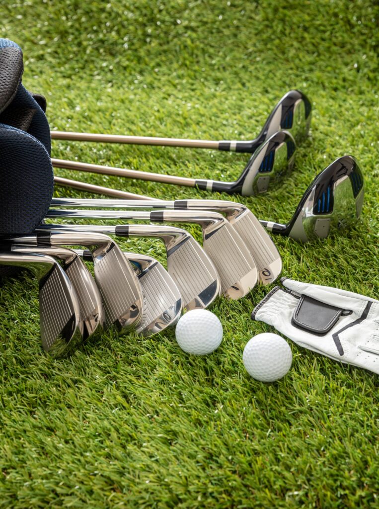 Golf equipment on green grass golf course, close up view.